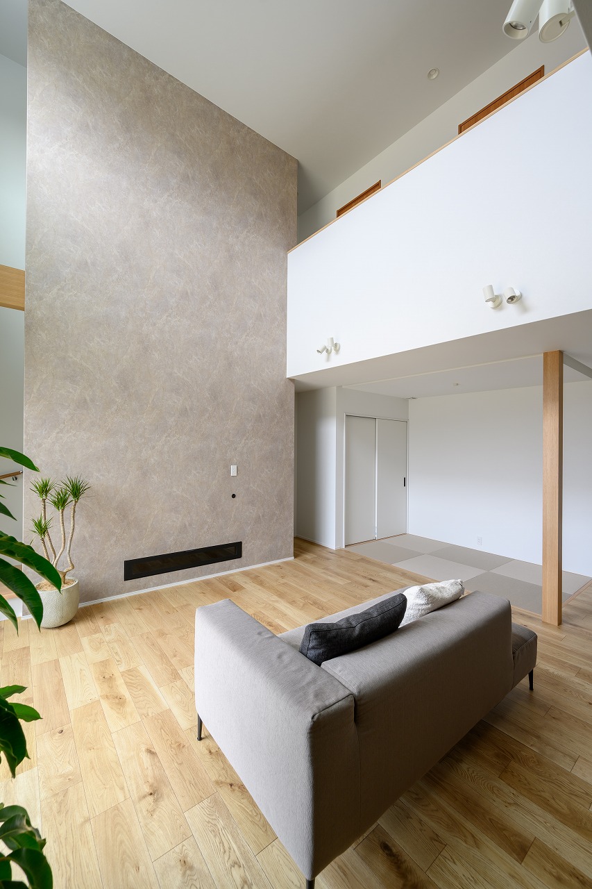 素材感で魅せる吹き抜けリビングのTV背面デザイン